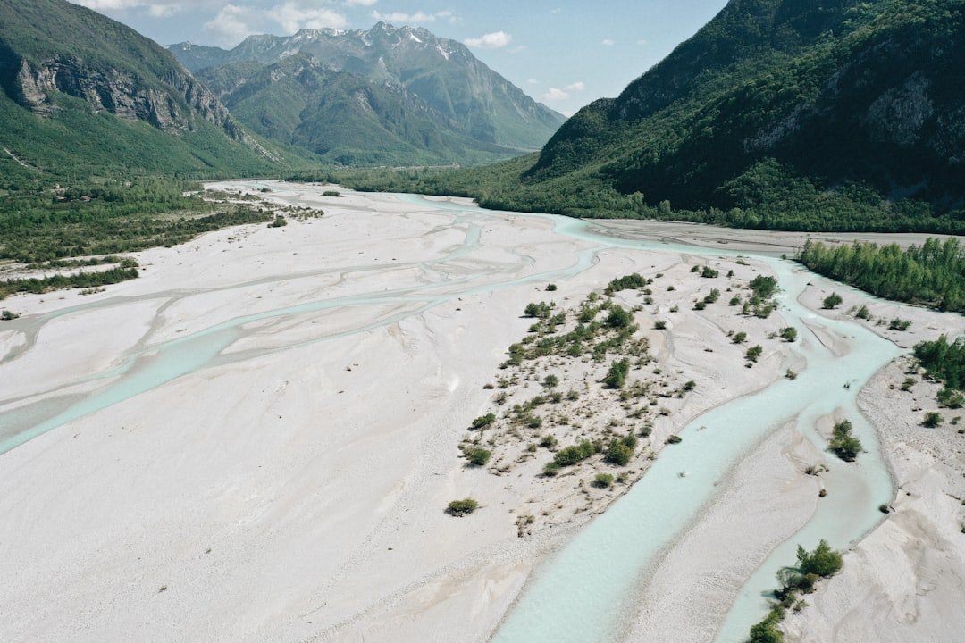 Scenic view of a winding river through a wide, sandy valley with mountains in the background, symbolizing a break from the daily IT routine.